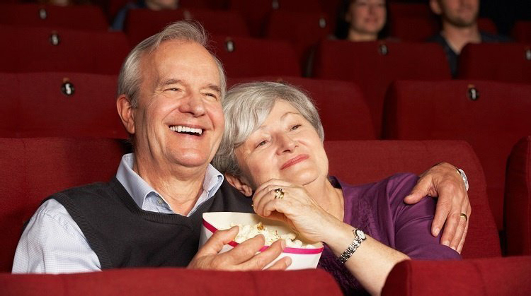 Senior couple enjoying movie at theater